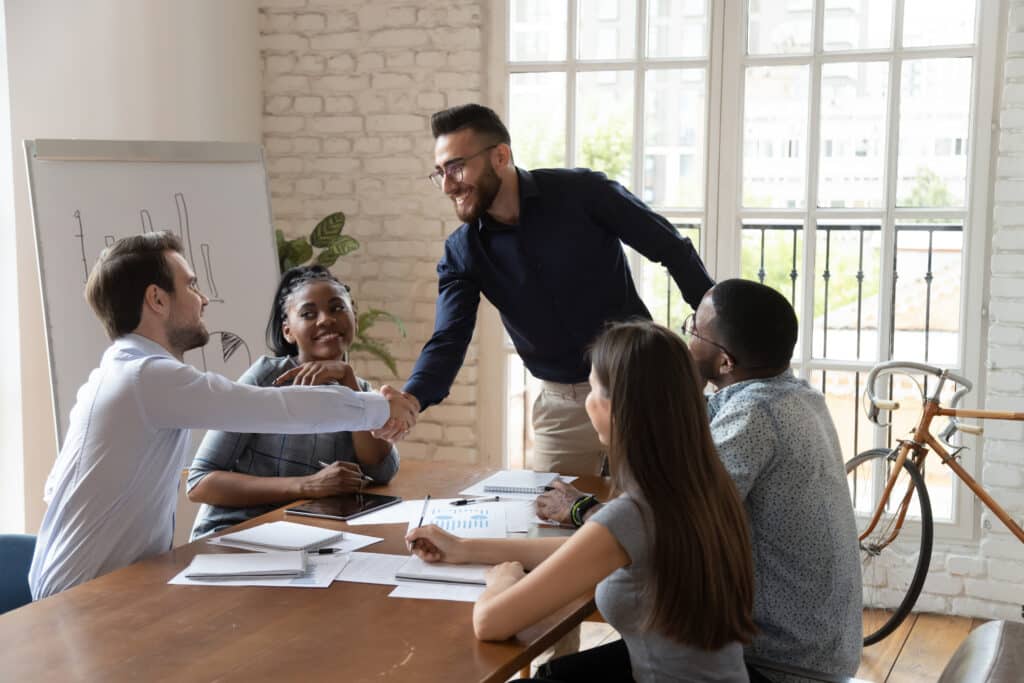 Arab and european business partners handshaking starting negotiations in boardroom 1767824524 c6df87cd4c3e48f8b11dda8ac563d56f 1